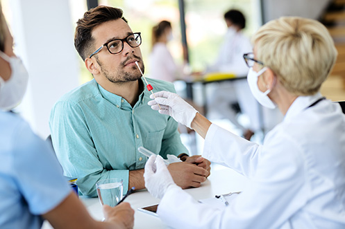 Young man getting PCR test for coronavirus during appointment at a pharmacy in Italy.